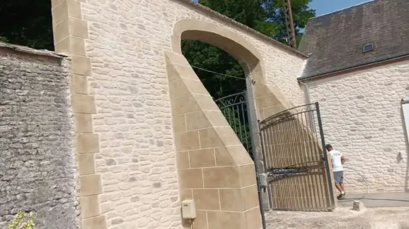 Mur d'enceinte avec porche cintré en enduit décor pierre et pilastres en pierre de taille